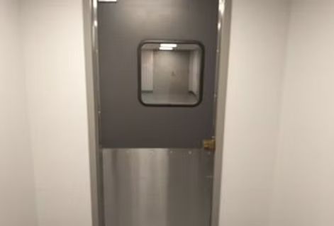 A stainless steel door with a window in a room.