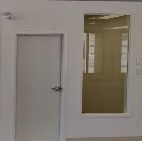 A white door with a glass window in a room.