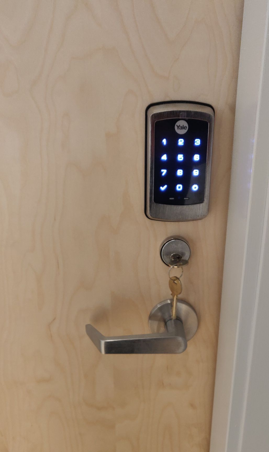 A door with a digital lock and keys on it.