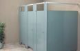 A row of blue toilet cubicles in a public restroom.