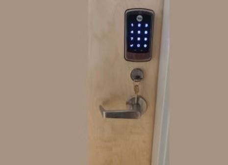 A close up of a door with a digital lock on it.
