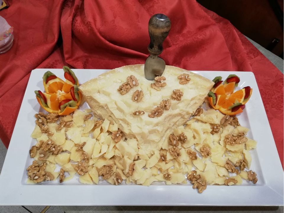 Un piatto decorato con un coltello, noci, fette d'arancia e una base di pasta sfoglia ripiegata.