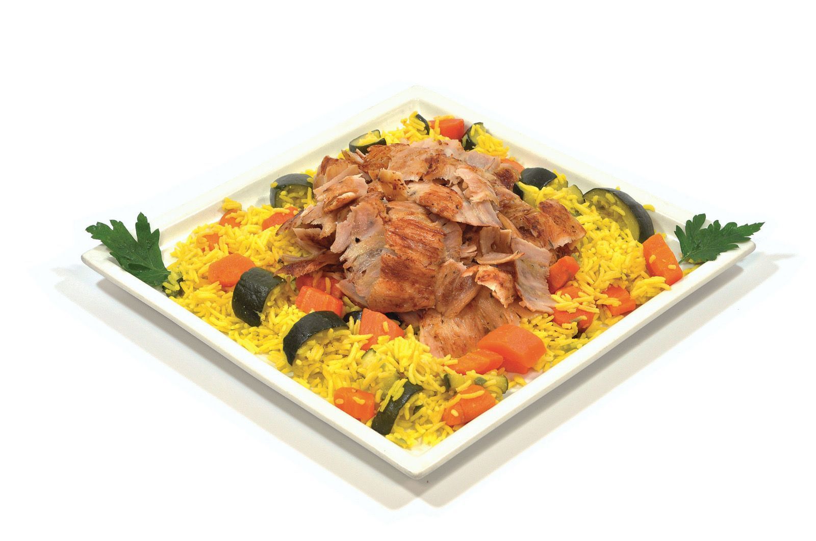 Una porzione di riso giallo guarnita con carne a fette, carote cotte e zucchine su un piatto quadrato bianco.