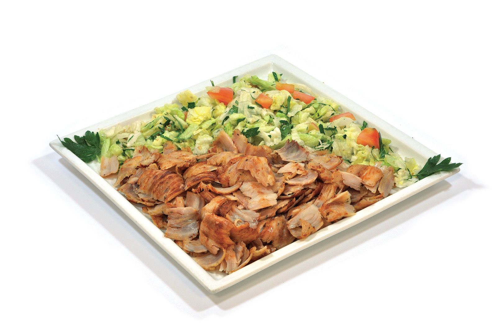 Un piatto quadrato bianco colmo di carne cotta tagliata a fettine sottili, accompagnato da un'insalata fresca di lattuga e pomodori tagliati a julienne.