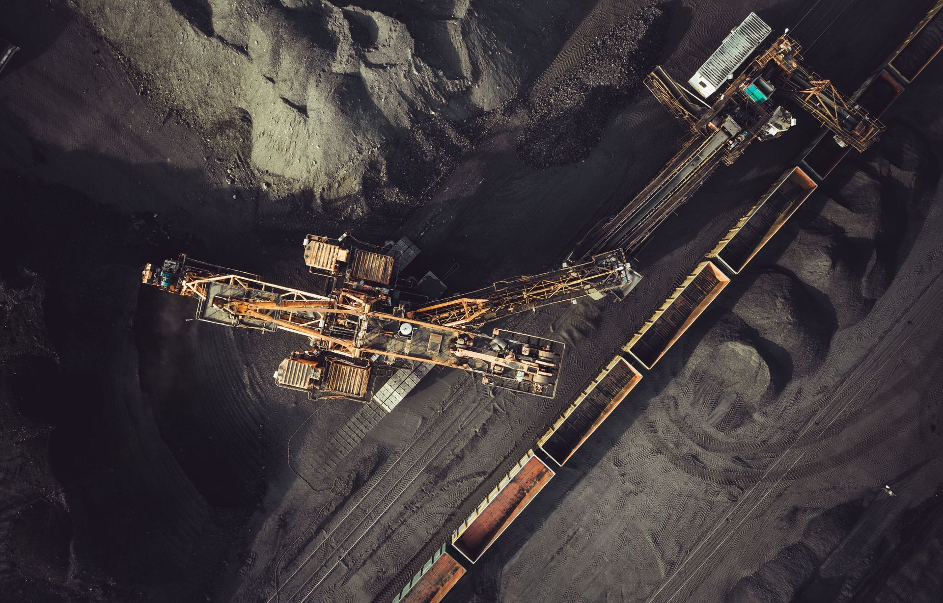 An aerial view of a coal mine with a train going through it.