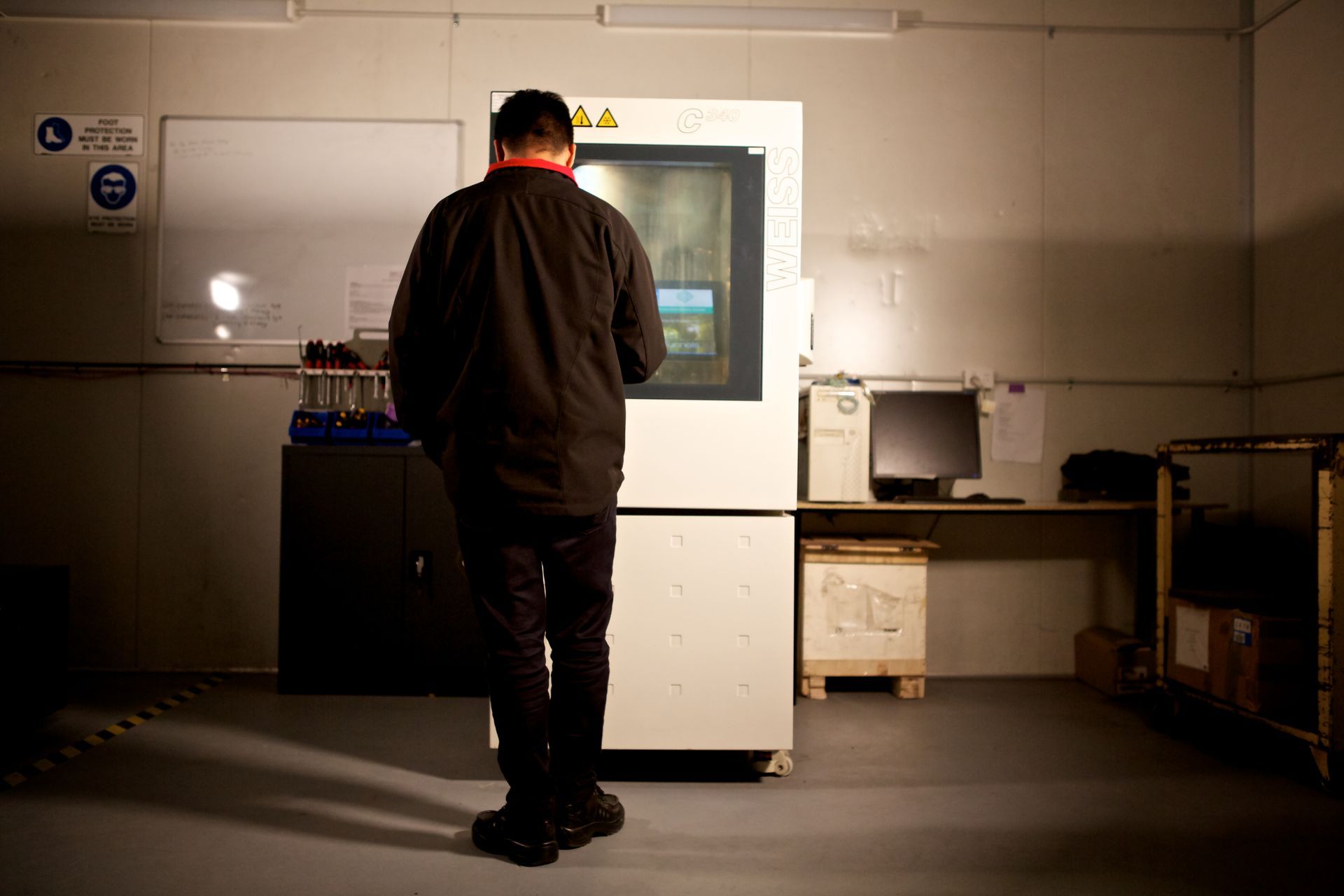 Skilled Environmental Testing operator standing in front of the Climatic Testing machine