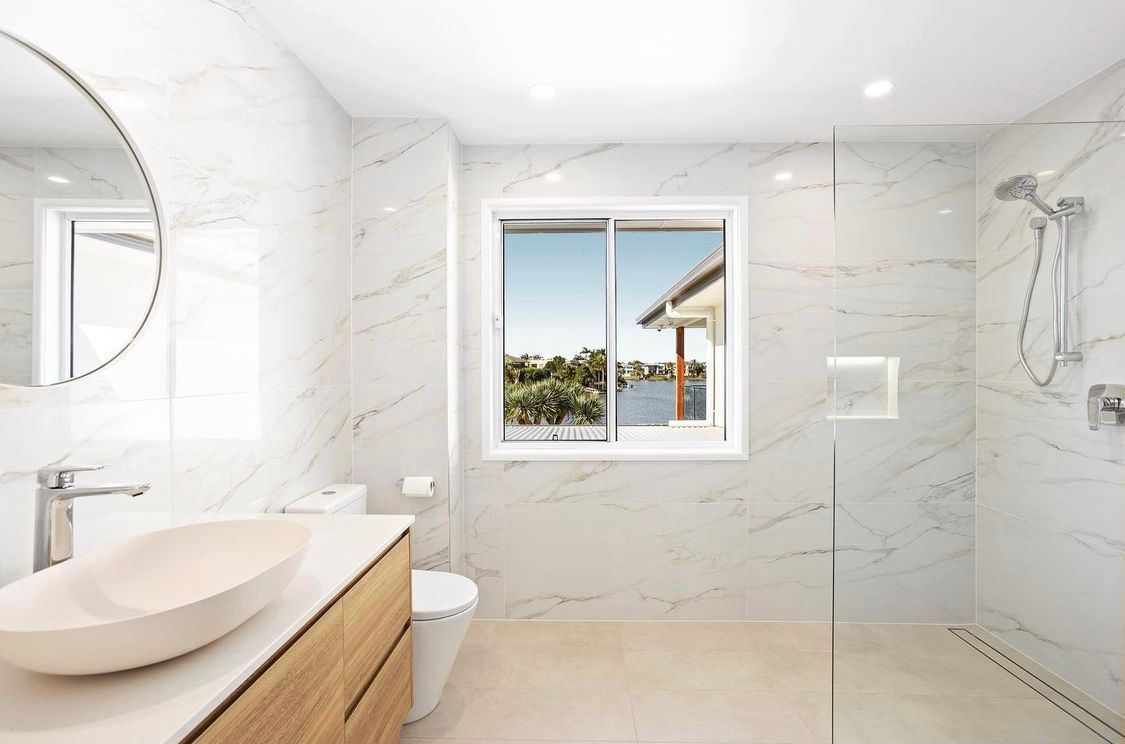 A Bathroom With a Sink, Toilet, Shower and Window — Hot Rock Granite In Burleigh Heads, QLD