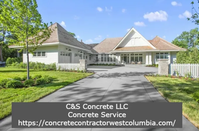 A light-colored house with a concrete driveway, grass lawn, and a link to a concrete contractor.