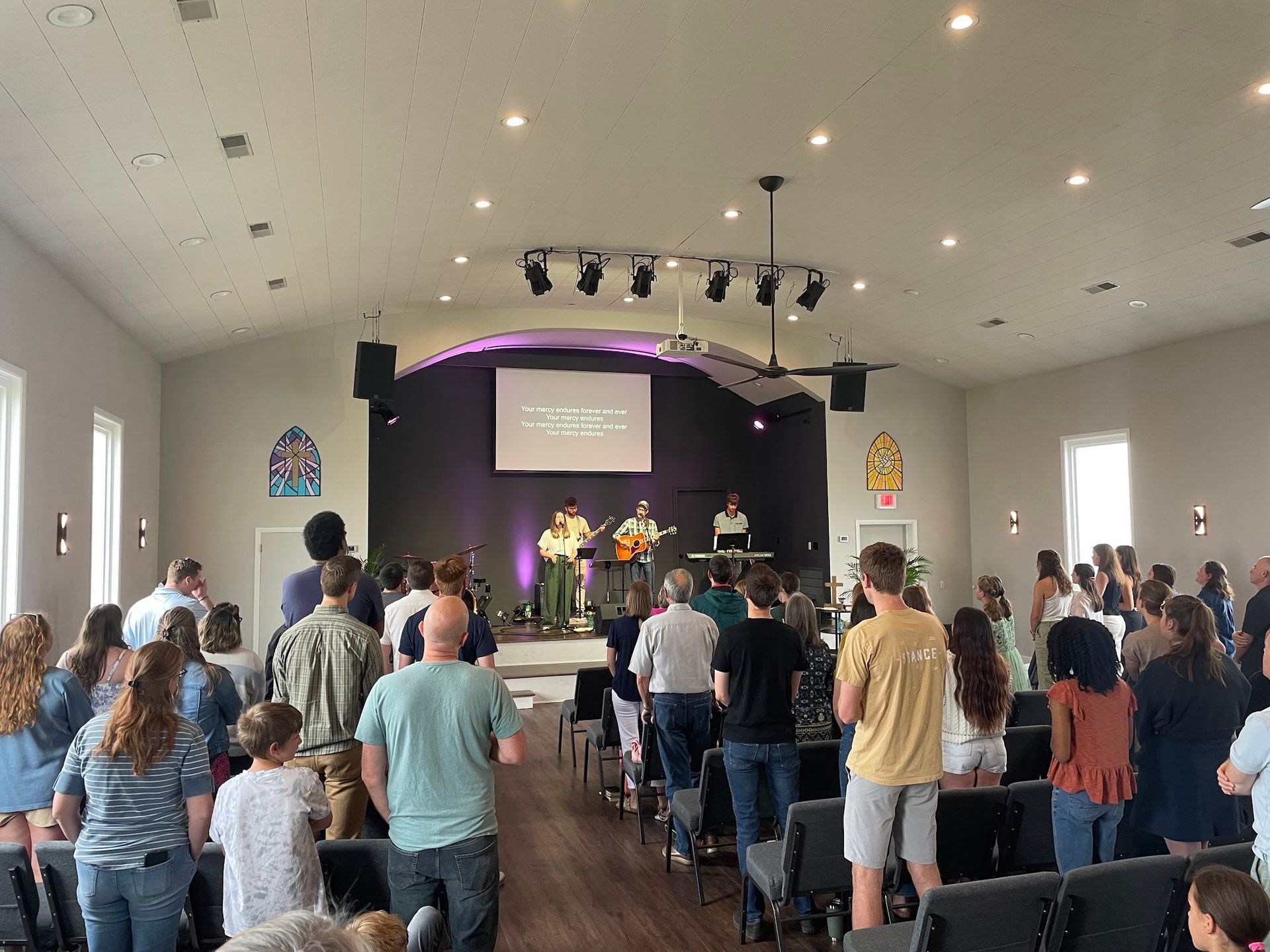 A large group of people are standing in a church.