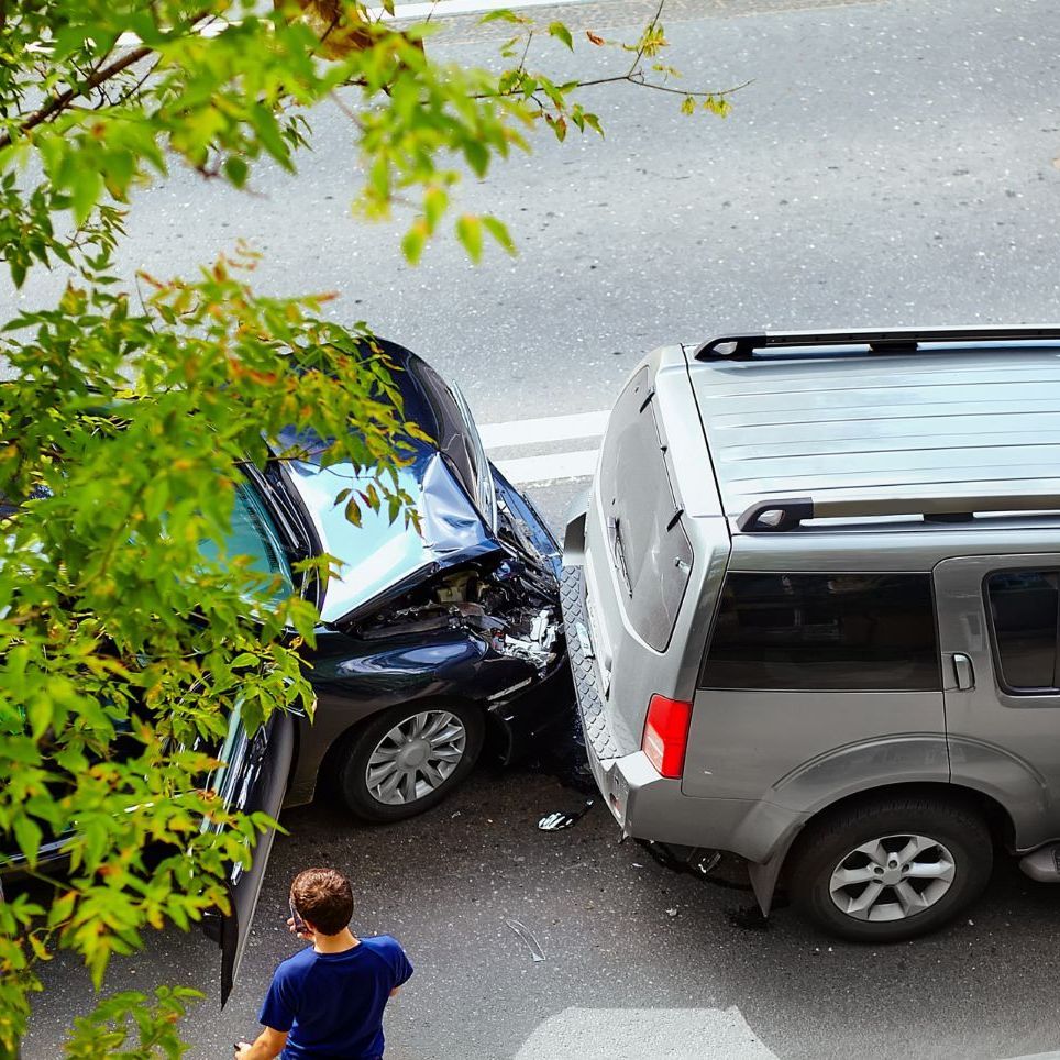 A person driving a car on a highway with a bridge in the background