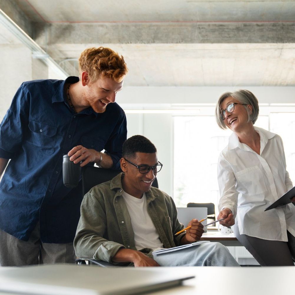 A man and woman are holding a baby on the beach.