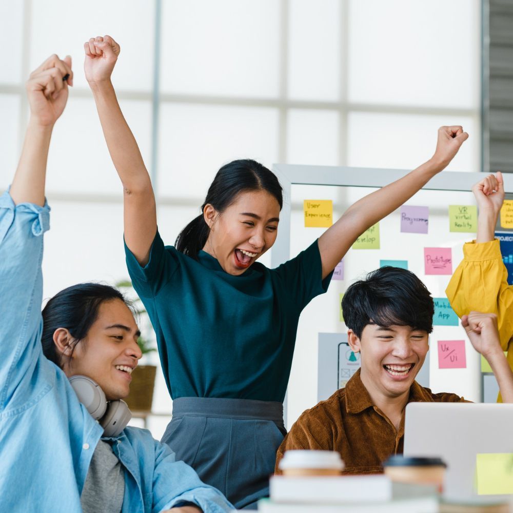 A woman and a child are giving each other a high five while sitting on the roof of a car.