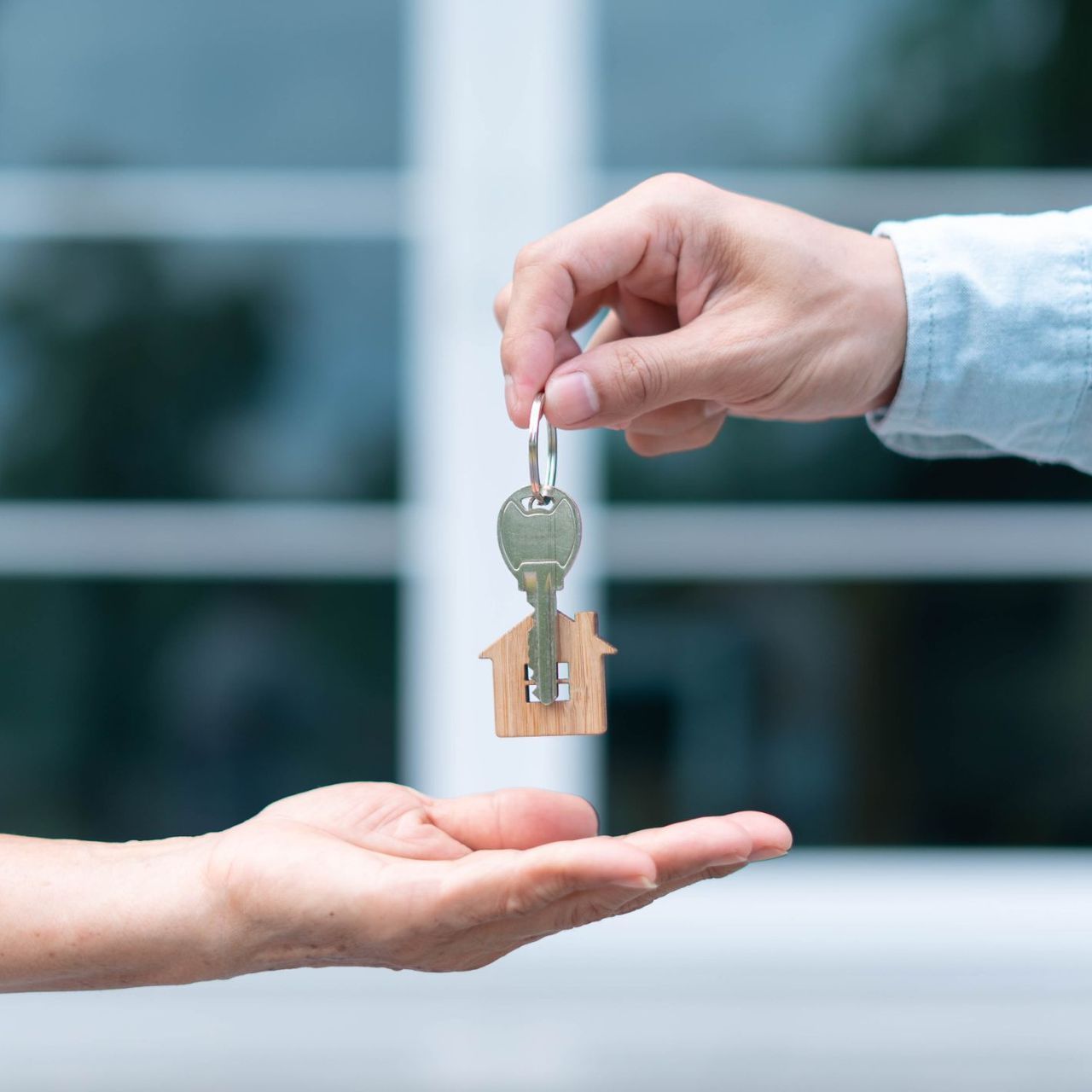 A woman and a child are giving each other a high five while sitting on the roof of a car.