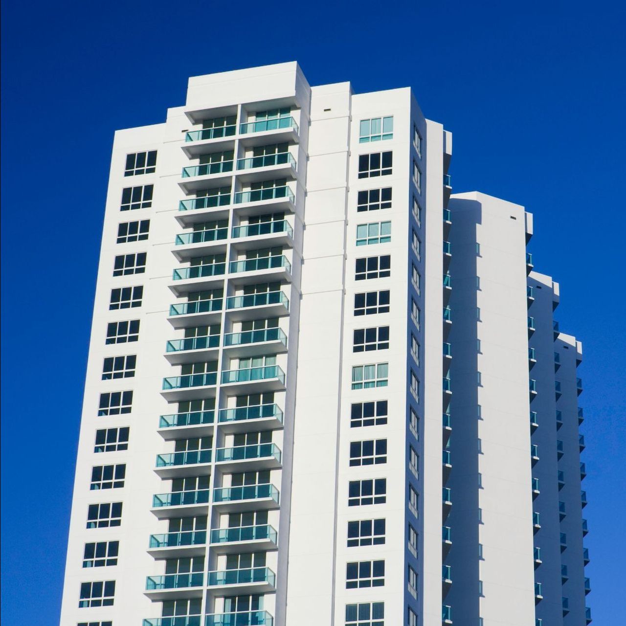 A man and woman are holding a baby on the beach.