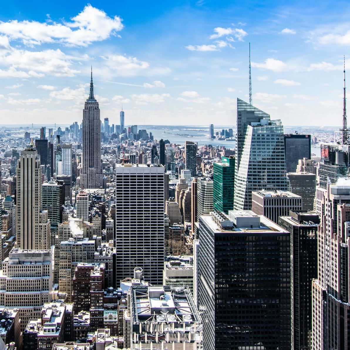 A person driving a car on a highway with a bridge in the background