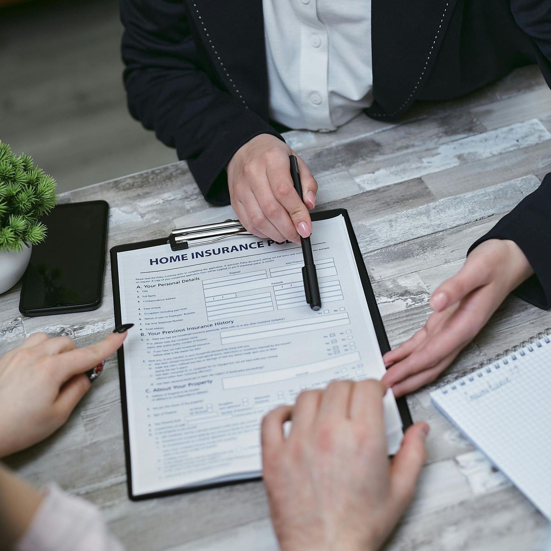 Two people are sitting at a table with a clipboard and a pen.