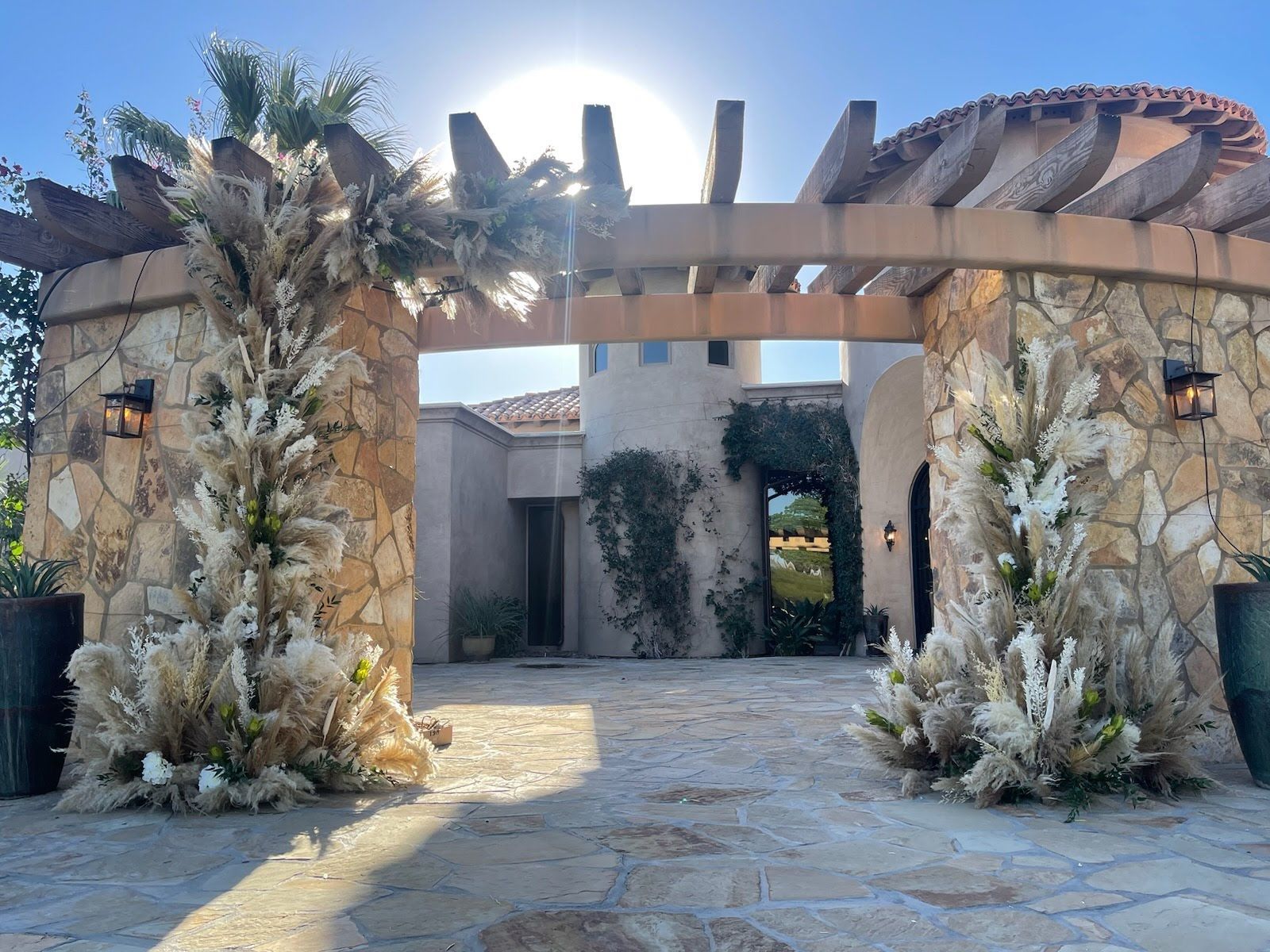 a stone archway with flowers in front of Mirabella