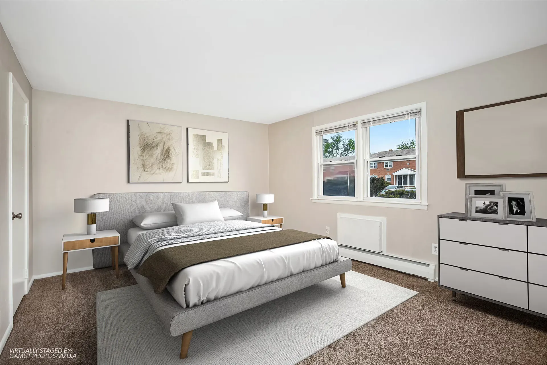 Bedroom in a modern apartment with a gray upholstered bed, two nightstands, and a window.