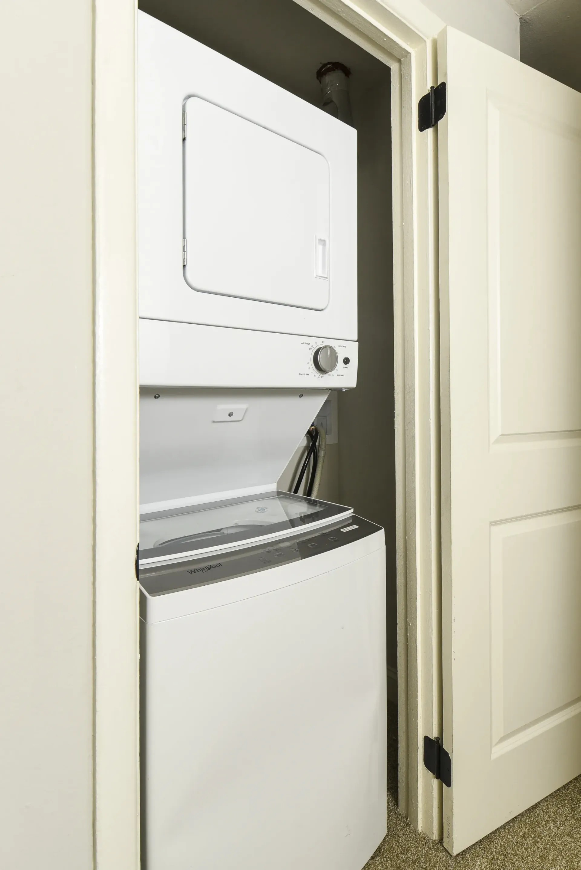 In-unit laundry closet with a stacked washer and dryer.