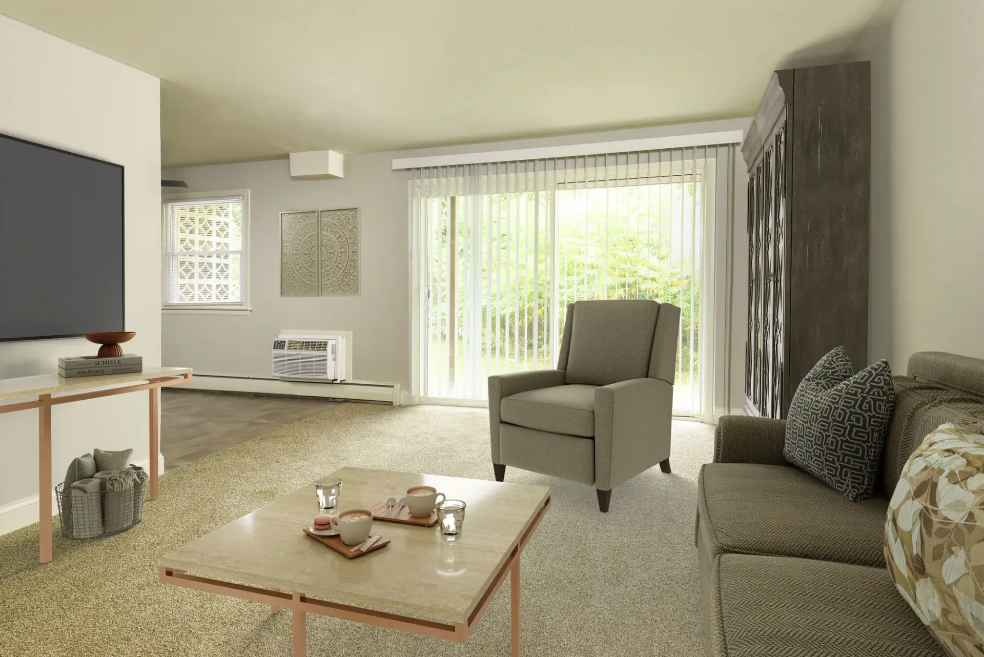 Living room in an apartment with sofa, chair, coffee table and sliding glass doors with vertical blinds.