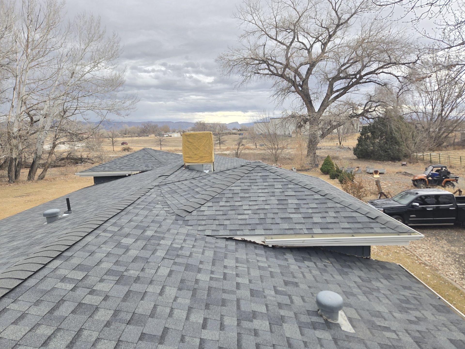 A roof of a house with a car parked on the side of it.