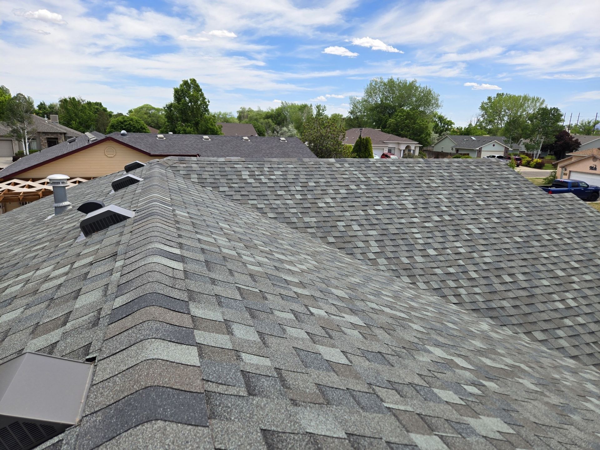 A roof with a lot of shingles on it in a residential area.