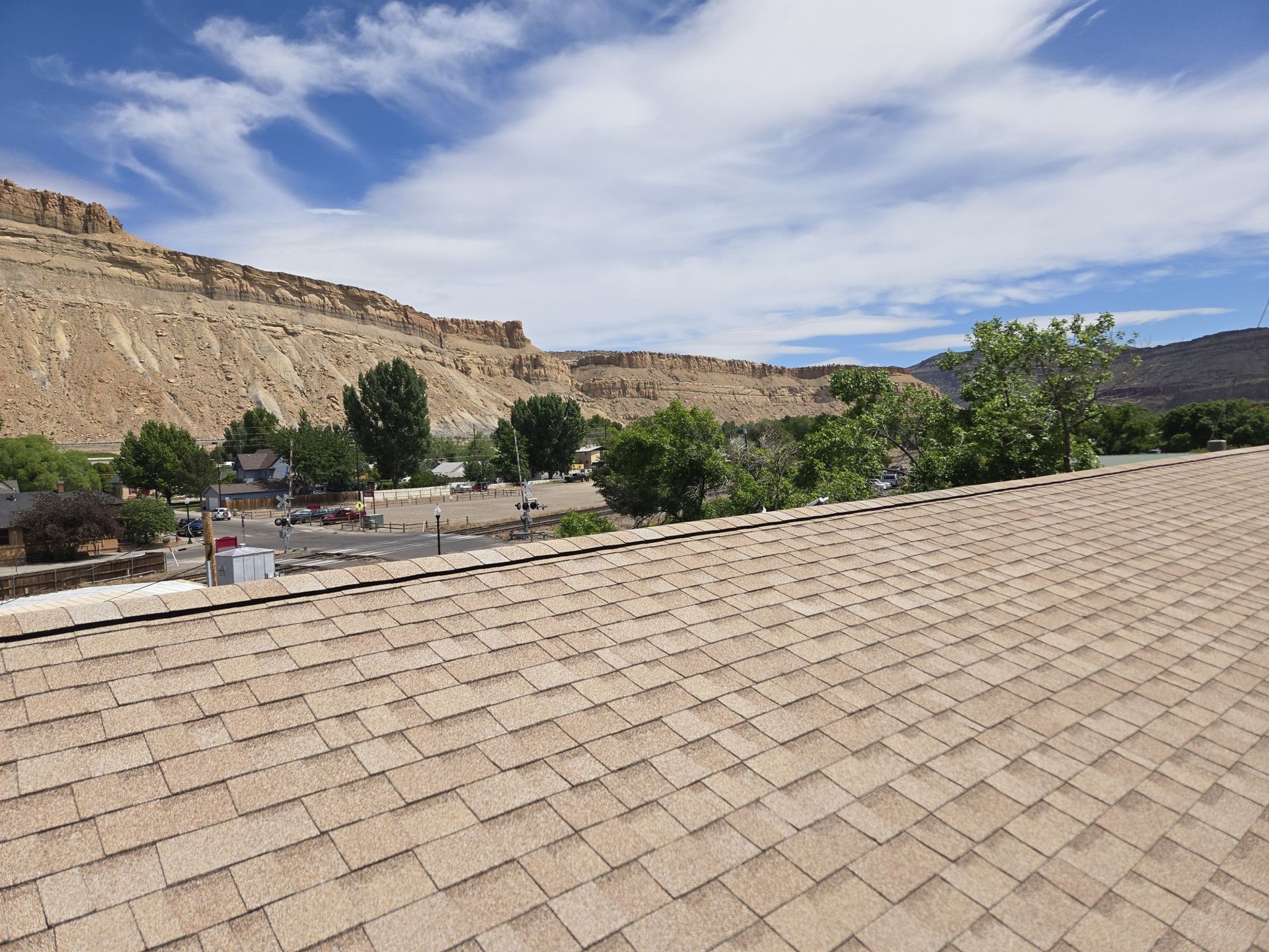 A roof with a mountain in the background and trees on it