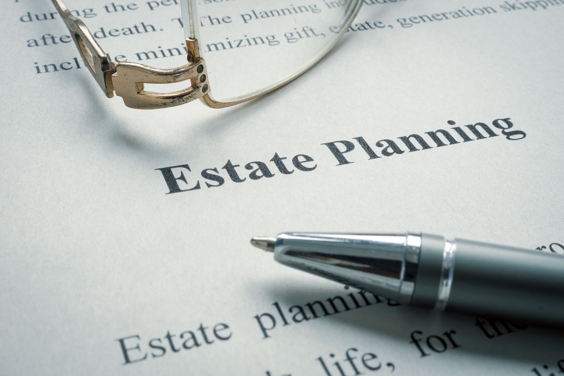 A pair of glasses over an estate planning document. A pair of glasses over an estate planning document.