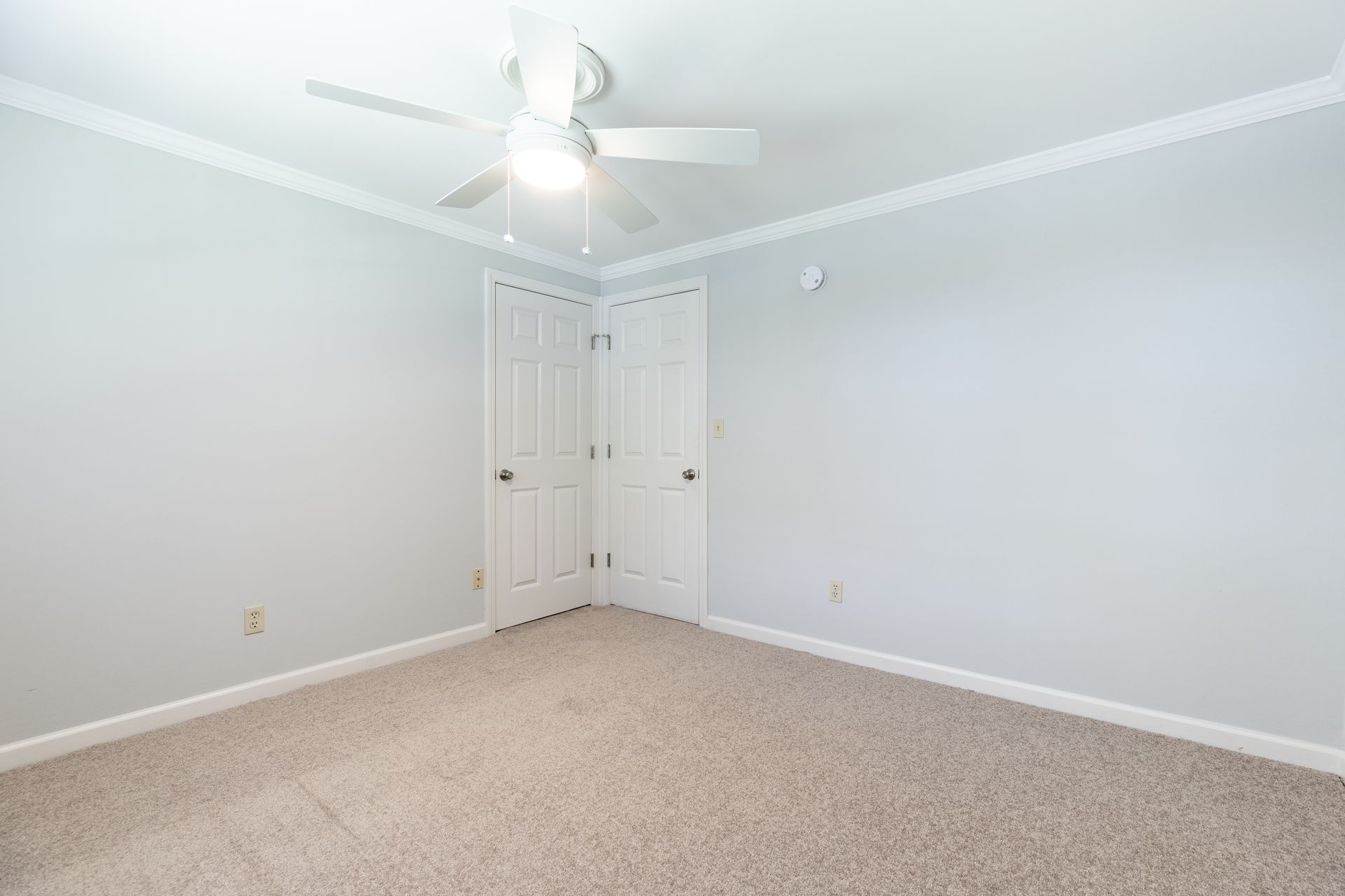 There is a ceiling fan in the corner of the room.