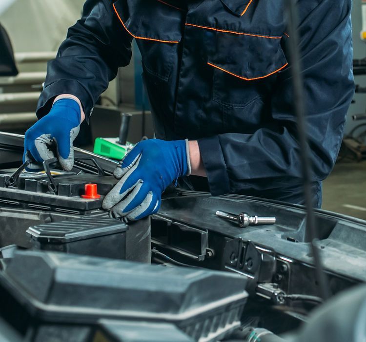 A man is working on the engine of a car.