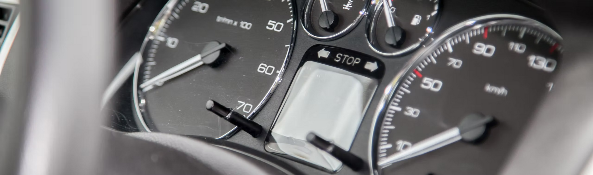 A close up of a car 's speedometer with a phone in it.