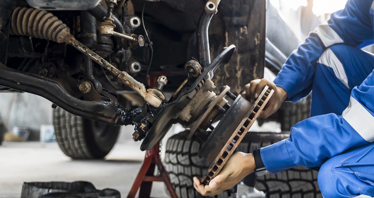 A mechanic is working on a car in a garage.