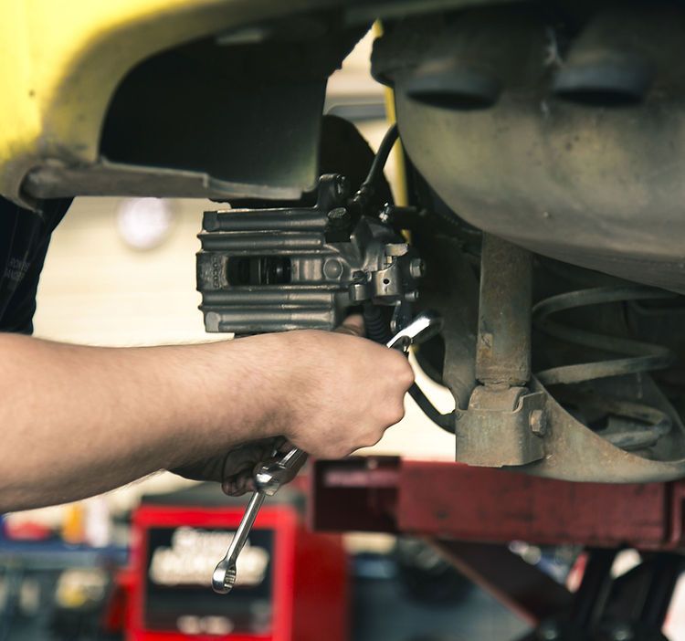 A man is working on a car with a wrench