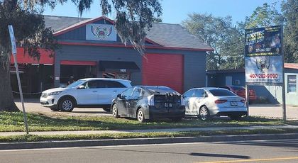 A group of cars are parked in front of a building.
