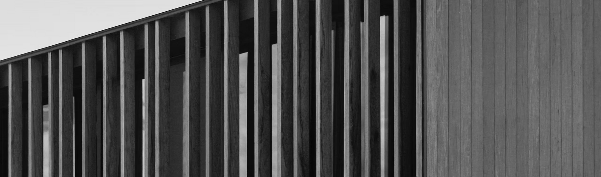 It is a black and white photo of a building with a fence.