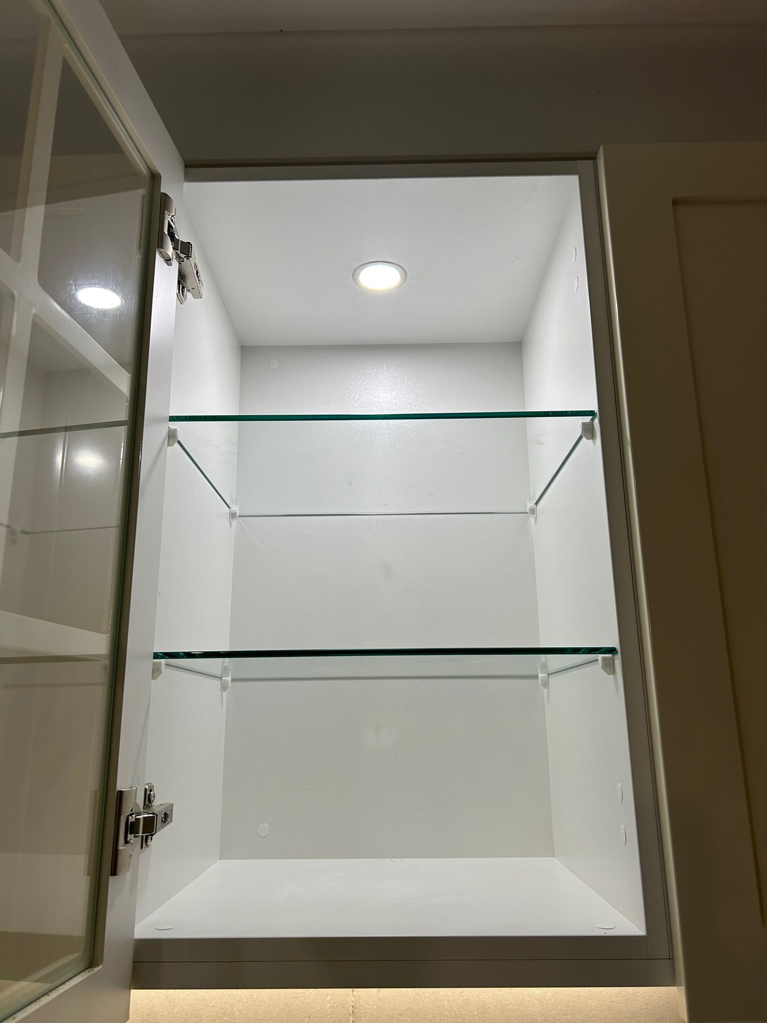 Open White Cabinet With Glass Shelves and Overhead Light — Fry Electrical In Budgewoi, NSW