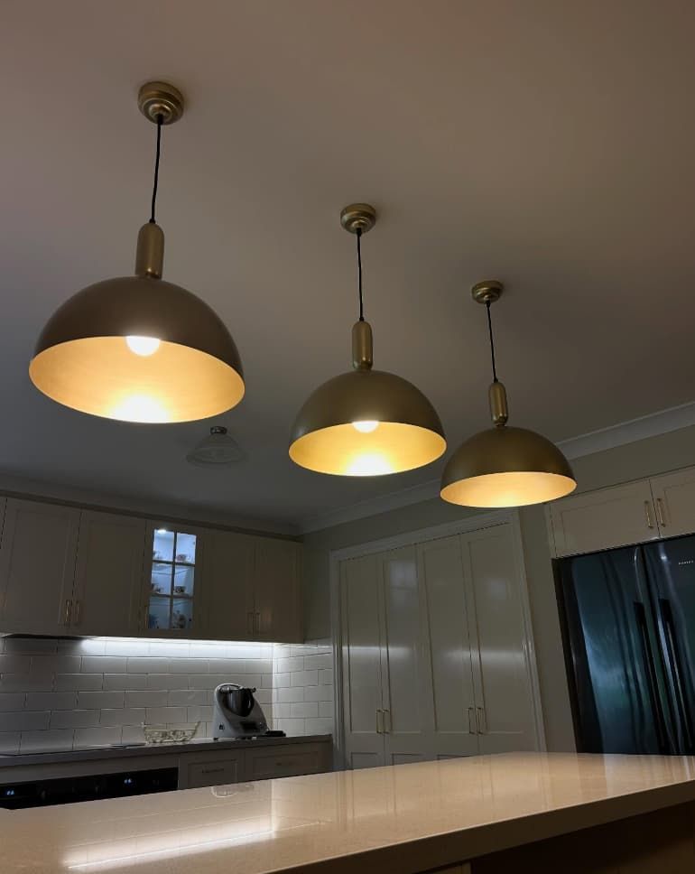 Three Gold Pendant Lights Hang Above A Kitchen Island — Fry Electrical In The Entrance, NSW