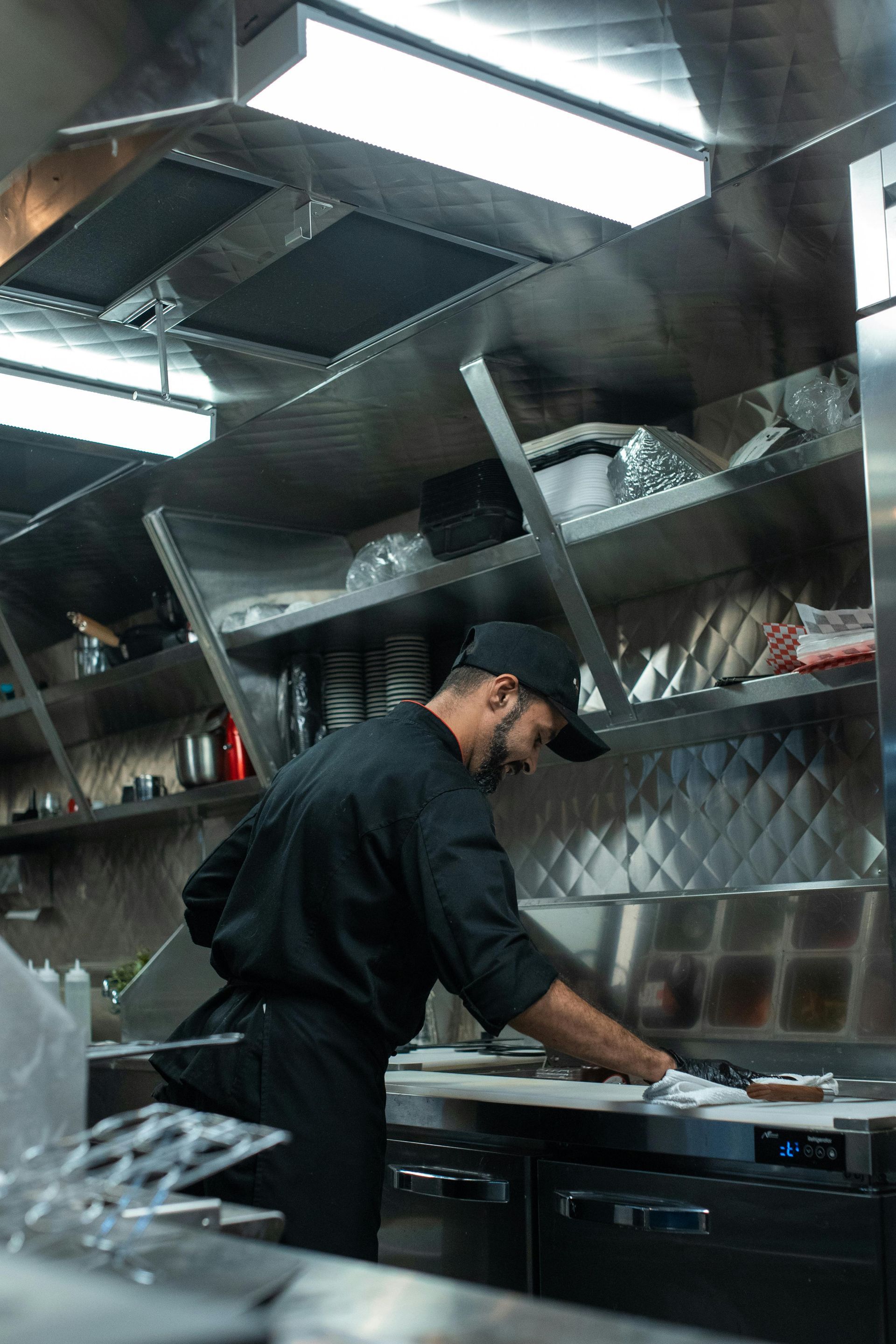 A man in a chef 's uniform is working in a kitchen.