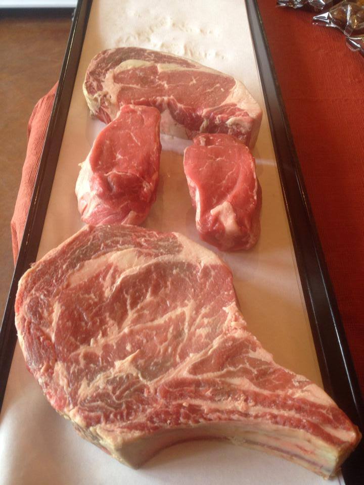 Three pieces of raw meat are sitting on a table