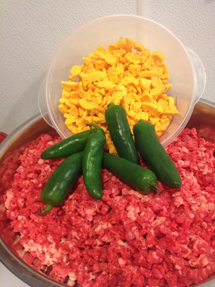 Jalapenos are being poured into a bowl of ground beef