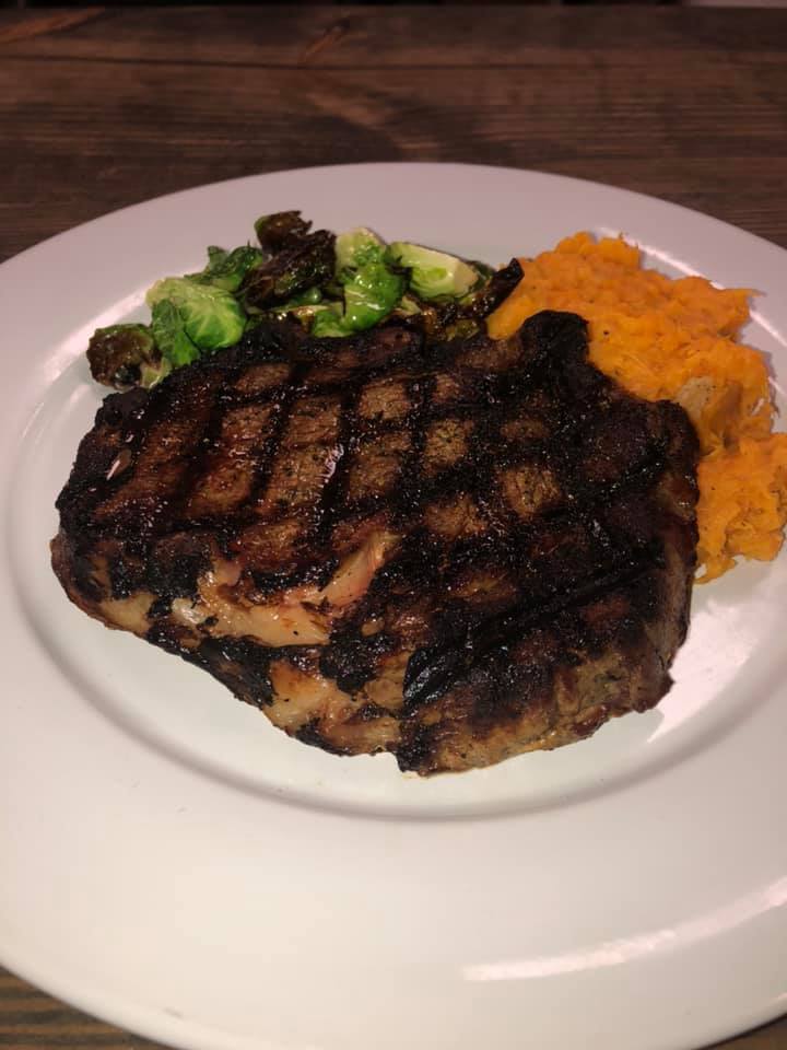 A white plate topped with a steak , broccoli and mashed potatoes.