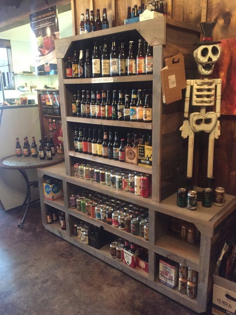 A shelf filled with bottles and cans of beer