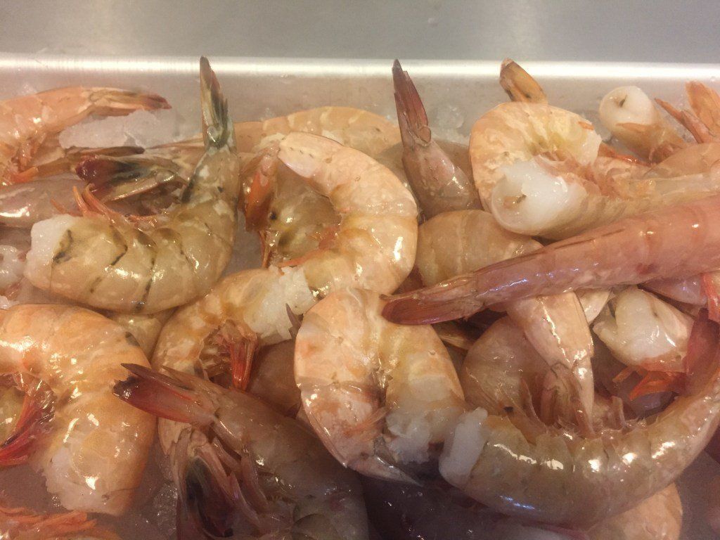 A bunch of shrimp are sitting on top of each other on a tray.