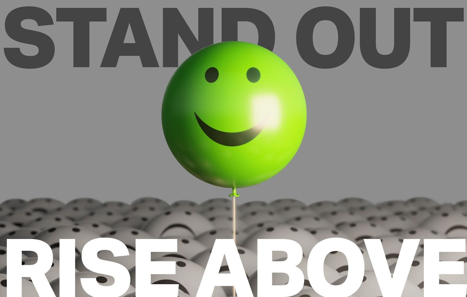 A green balloon with a smiley face on it and the words stand out rise above