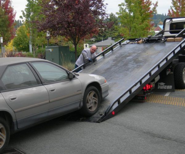 A car is being towed by a tow truck