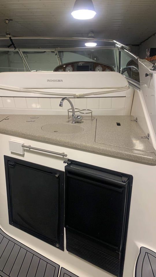 L'intérieur d'un bateau avec un évier et un réfrigérateur.