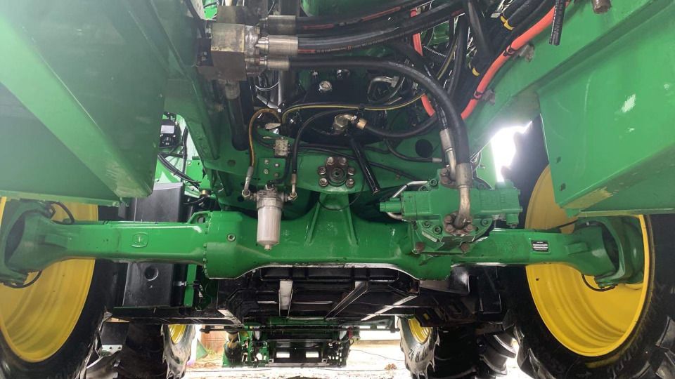 Le dessous d’un tracteur John Deere vert et jaune.