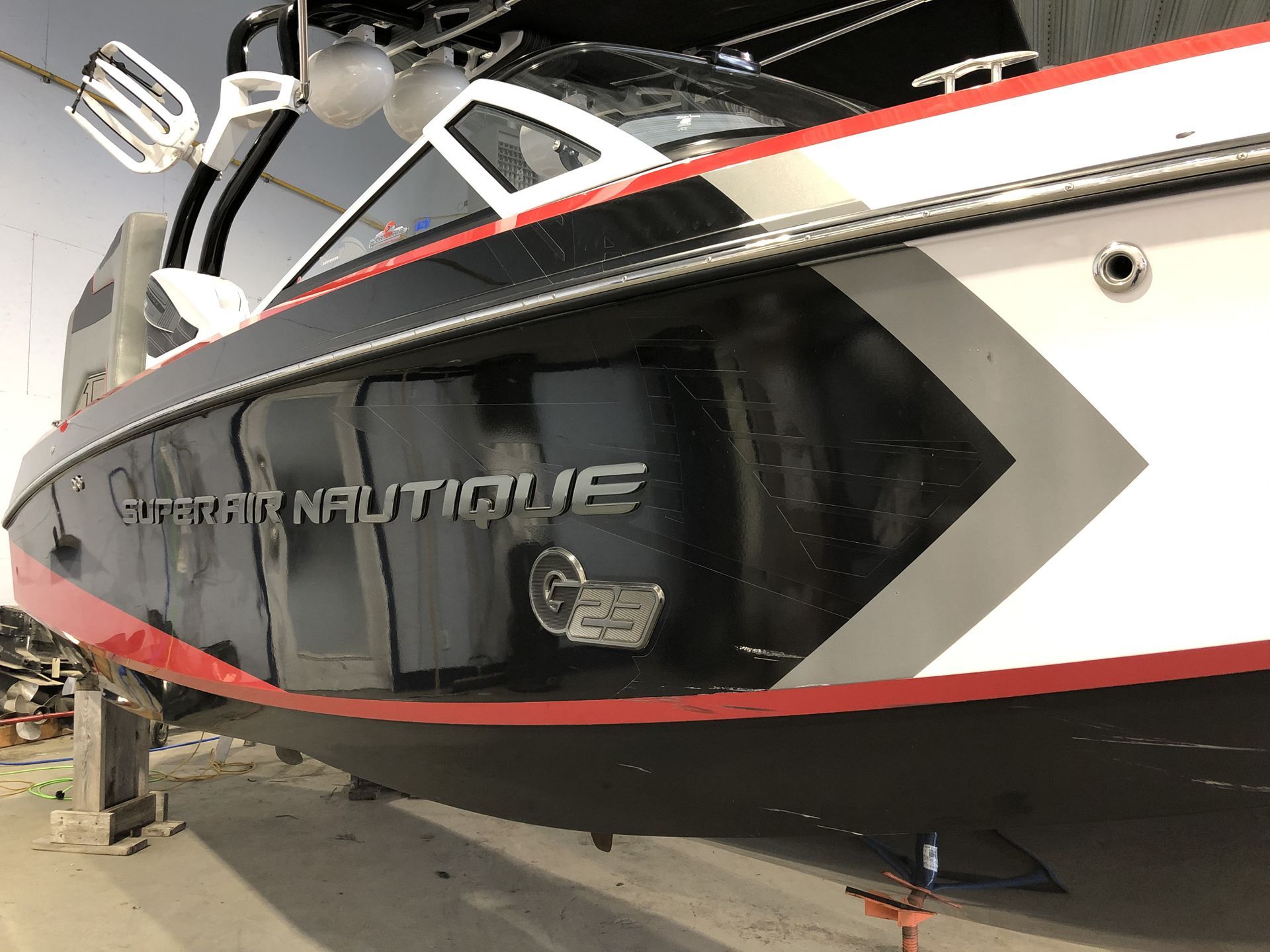 Un bateau rouge, blanc et noir est posé sur le sol.