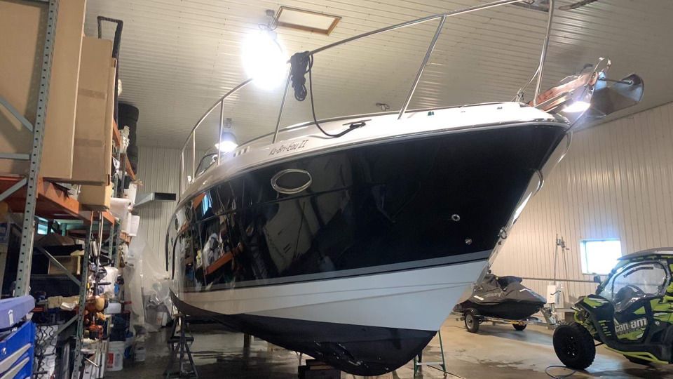 Un bateau est posé dans un garage à côté d'un canot.