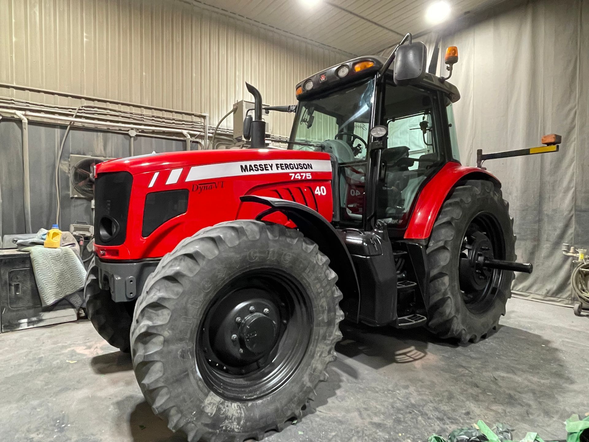 Un tracteur rouge est garé dans un garage.